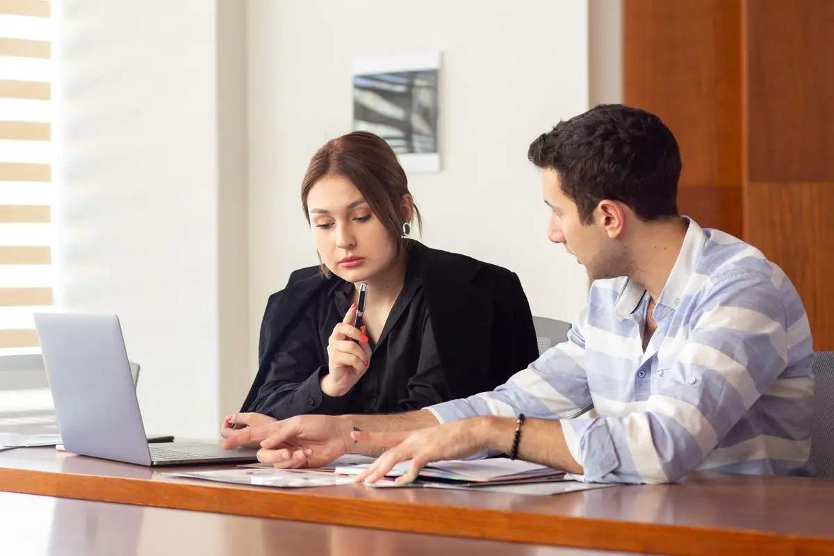 A woman and a man going through paperwork together at a table