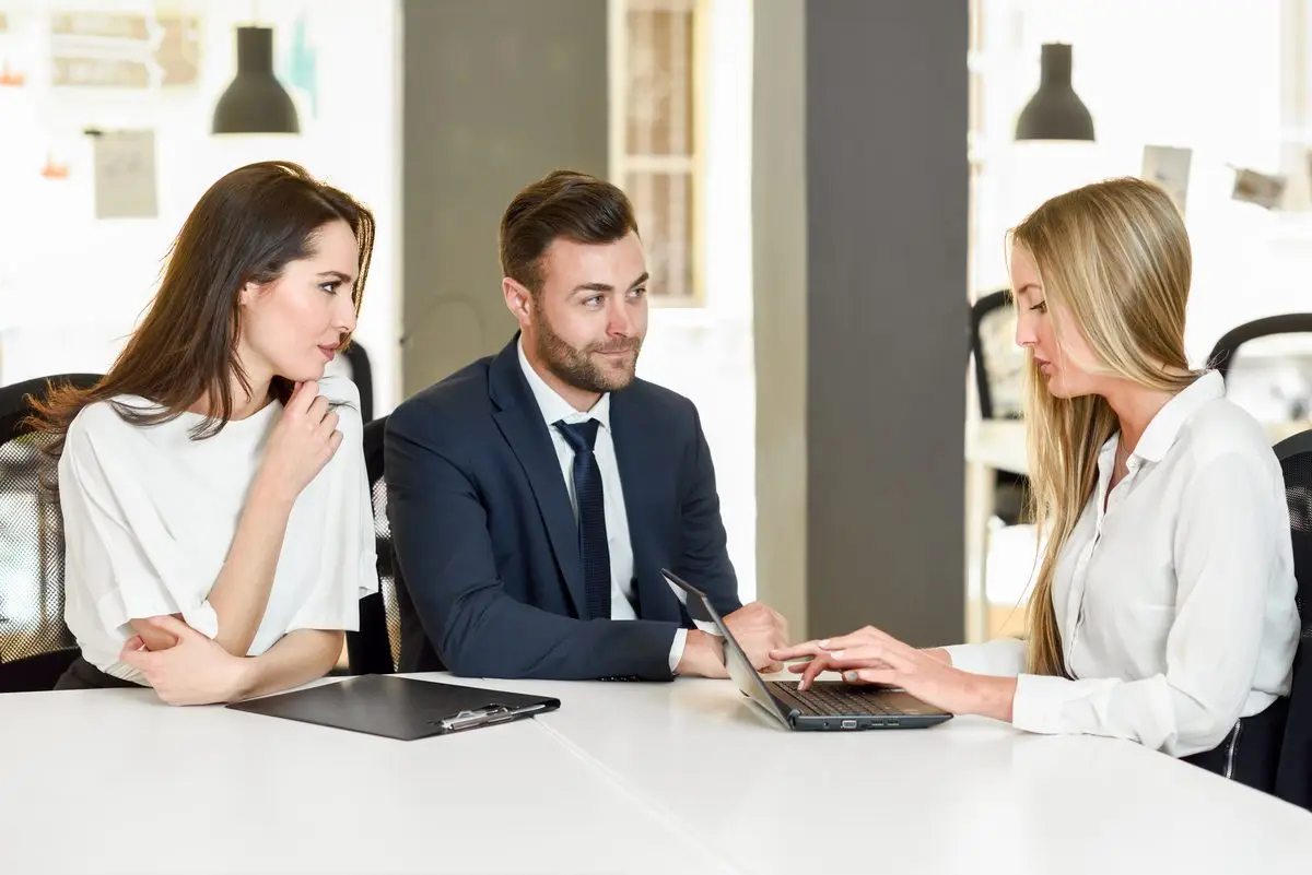 A family lawyer explaining the issues to a couple across a bright office table