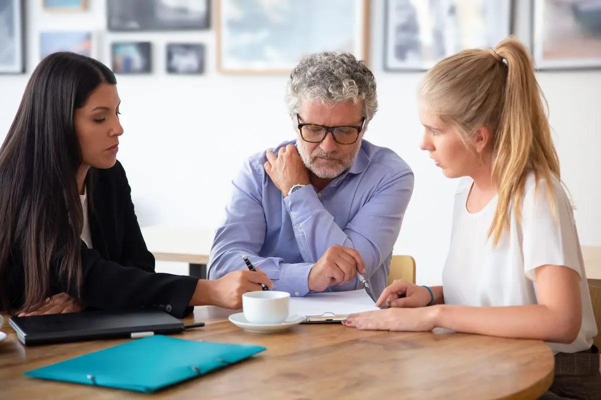 A family legal advisor explaining a document to a father and his adult daughter