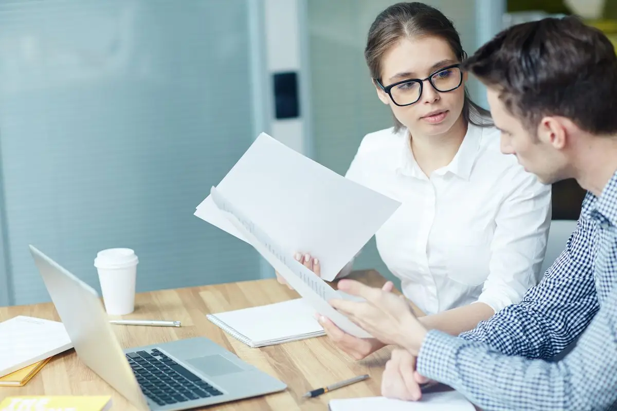 A lawyer and a client reviewing a document together across a desk during a consultation