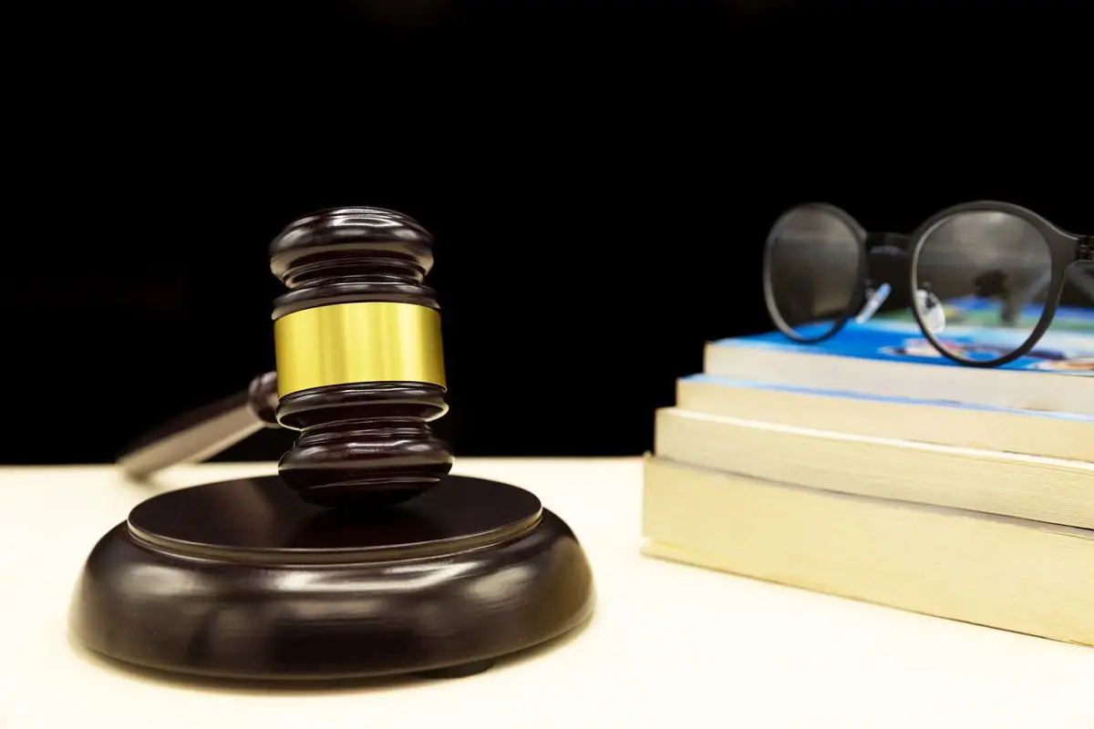 A gavel and law book resting on a court desk