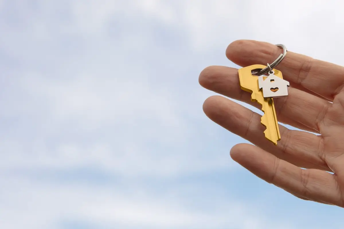 An open hand holding house keys on a keyring