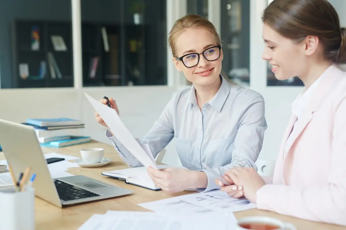 A woman explaining a document to a client in a bright office