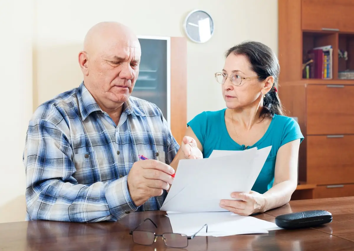 An older couple filling in a questionnaire at a table