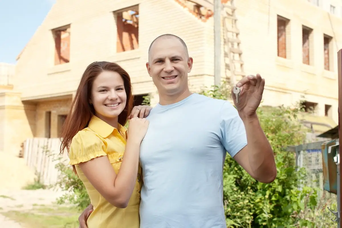 A couple standing together in front of their house