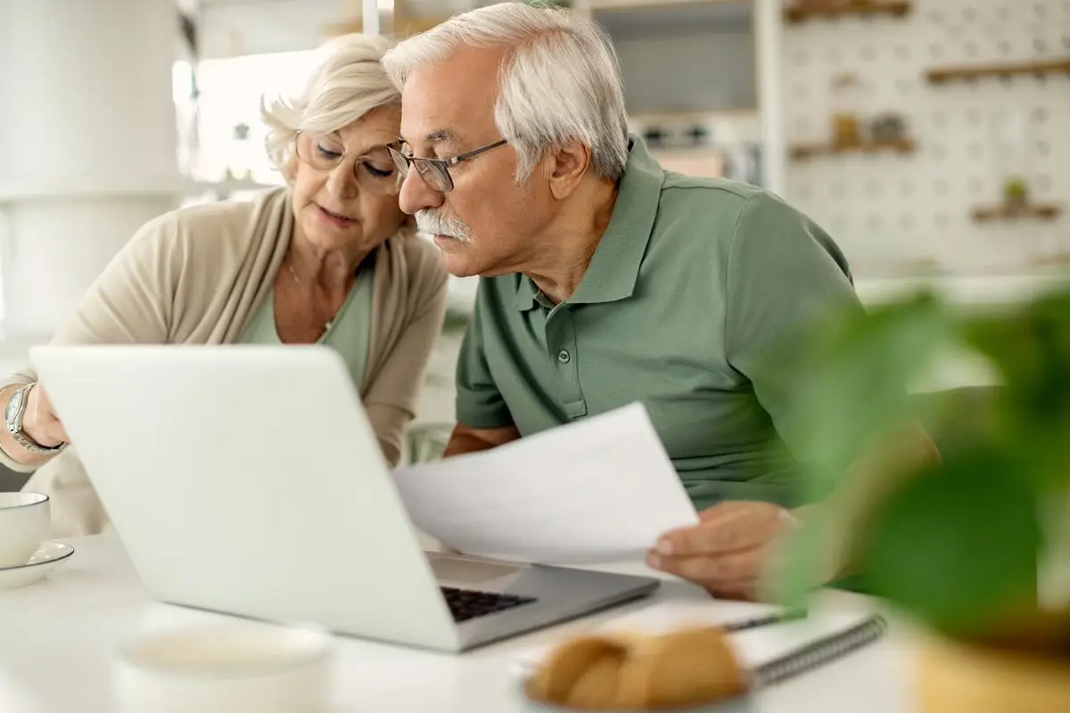 A senior couple reviewing their savings and pension papers at home