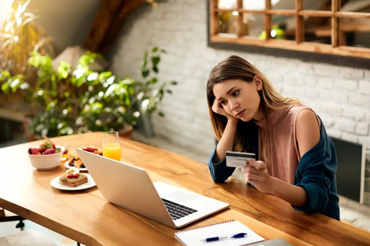 A woman looking worried while checking her online bank account