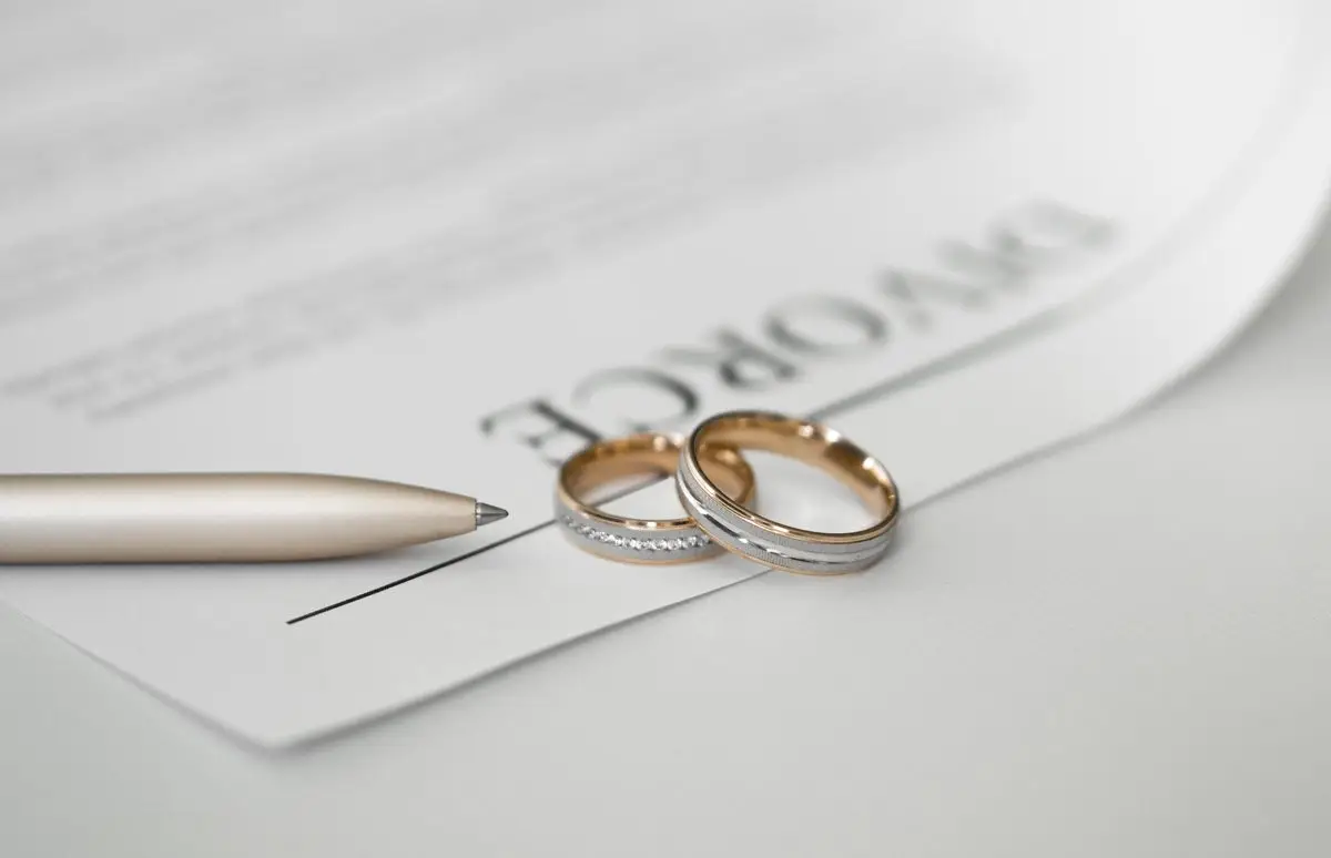 A divorce form with two wedding rings resting on it