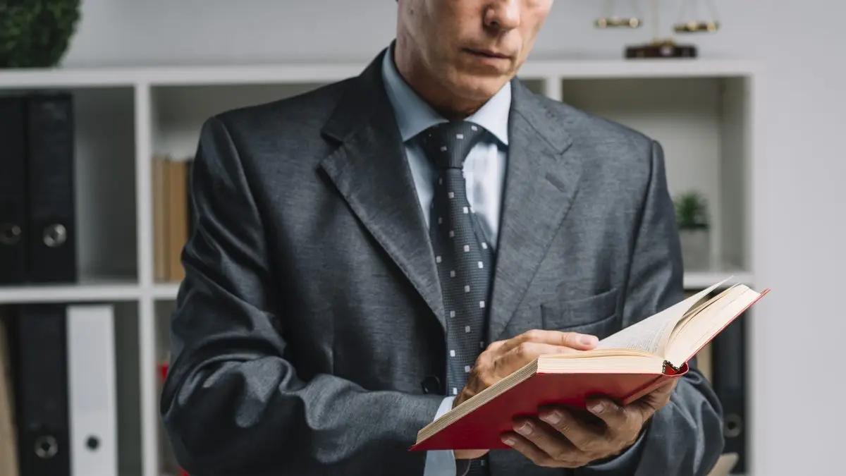 A lawyer reading a law book in an office