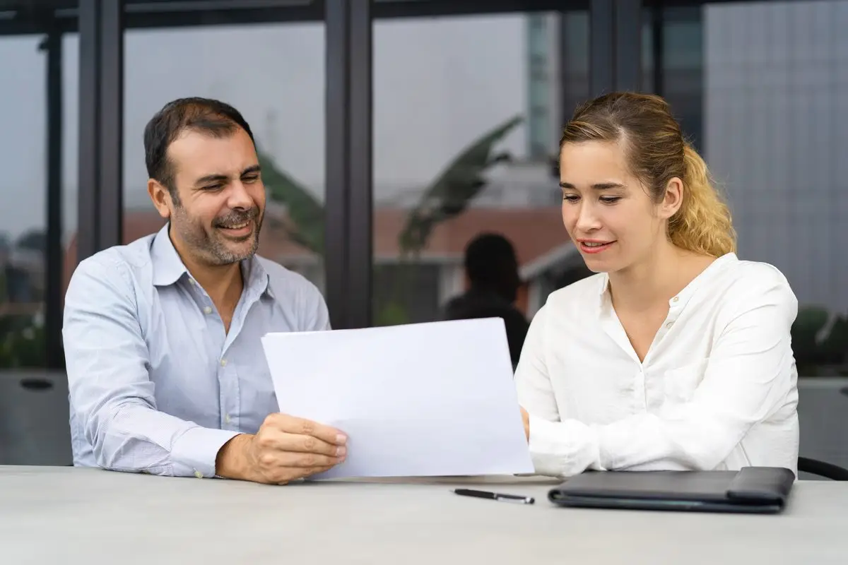 A man and a woman at a table reviewing an agreement together