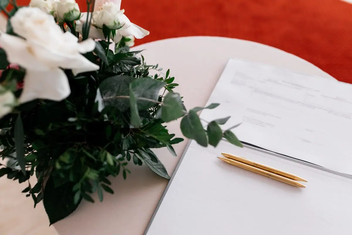 Marriage registration papers on a table beside a bouquet of white flowers